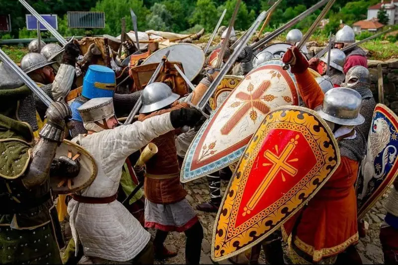 Mischia di rievocatori con scudi dipinti, elmi e cotte di maglia
